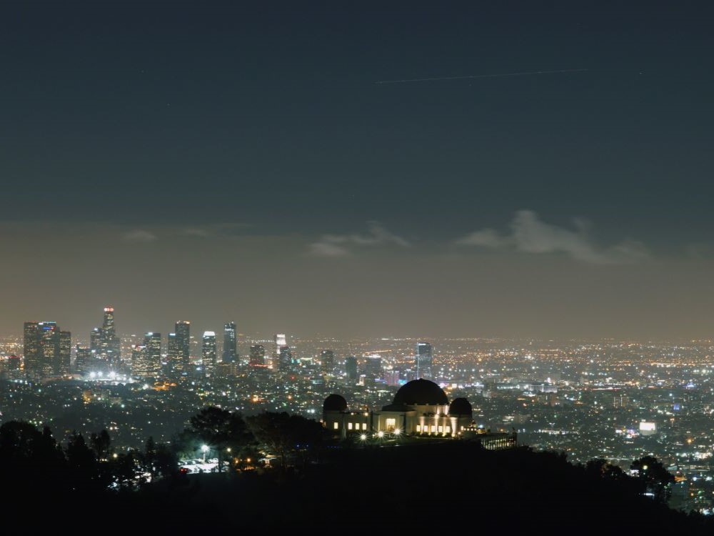Griffith Observatory at dusk with city lights below in Los Angeles