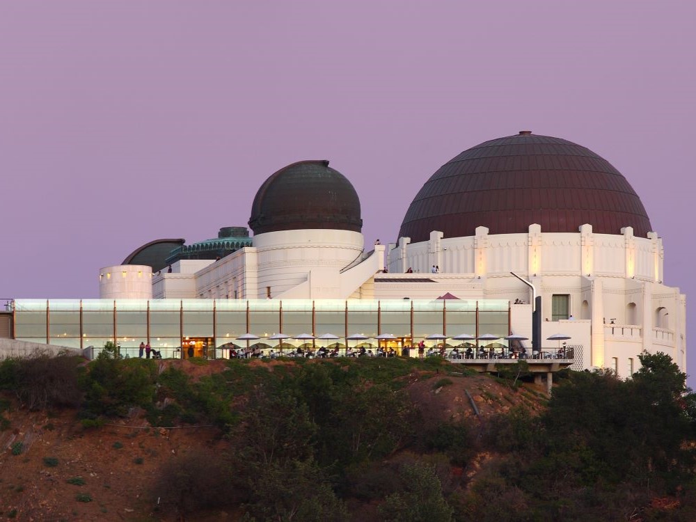 Griffith Observatory at dusk with city lights below in Los Angeles