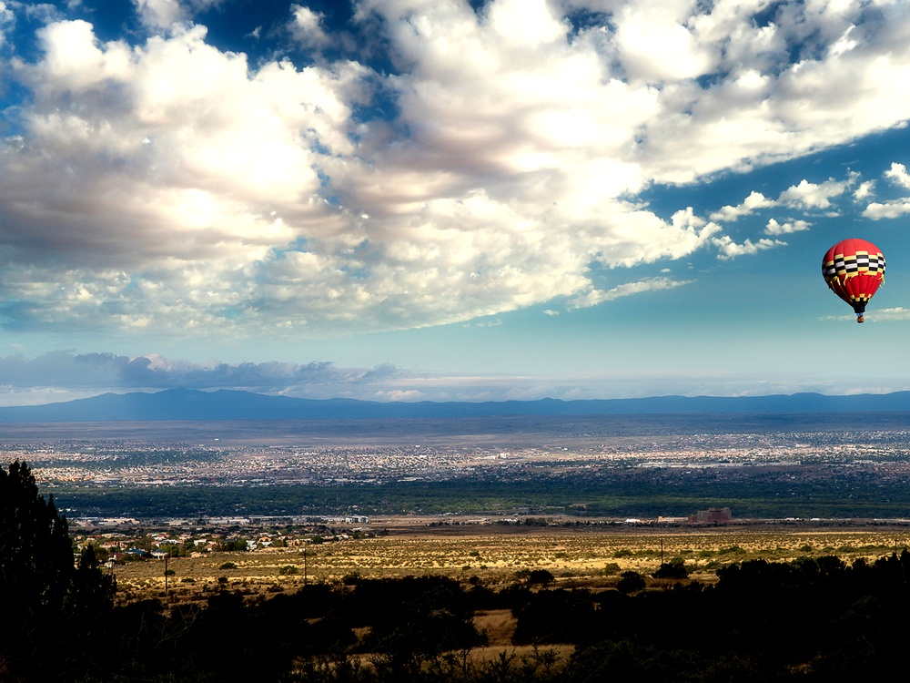 Hot air balloon ascending over Albuquerque with the Sandia Mountains in the background, New Mexico