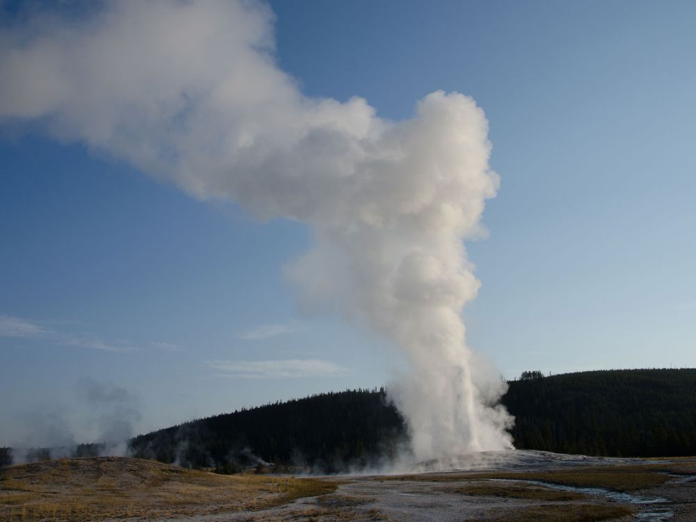 Old Faithful Geyser erupting in the evening light