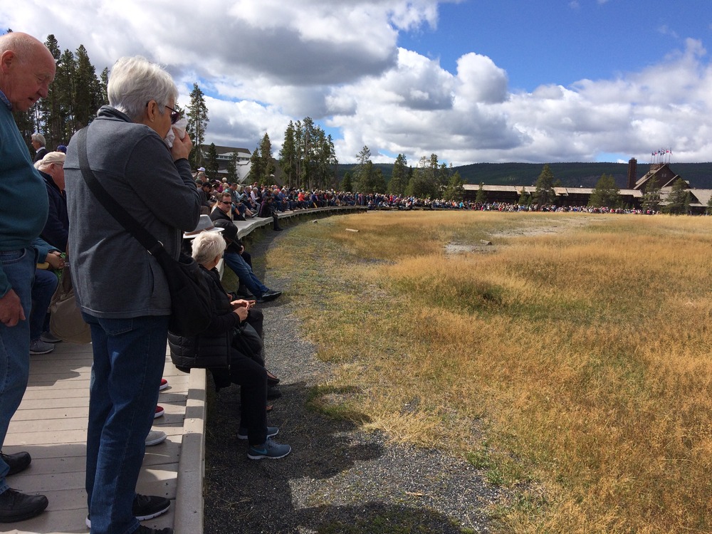 Crowds watching Old Faithful Geyser from the boardwalk