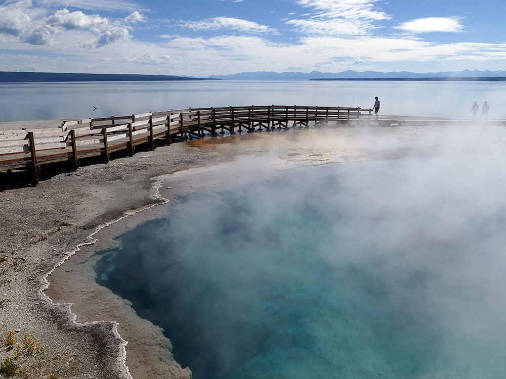 Boardwalk beside Black Pool's turquoise waters, Yellowstone Lake in the background