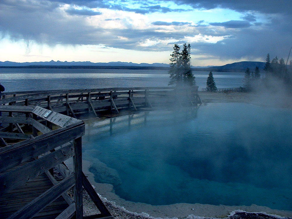 Black Pool steaming at dusk with Yellowstone Lake in the distance